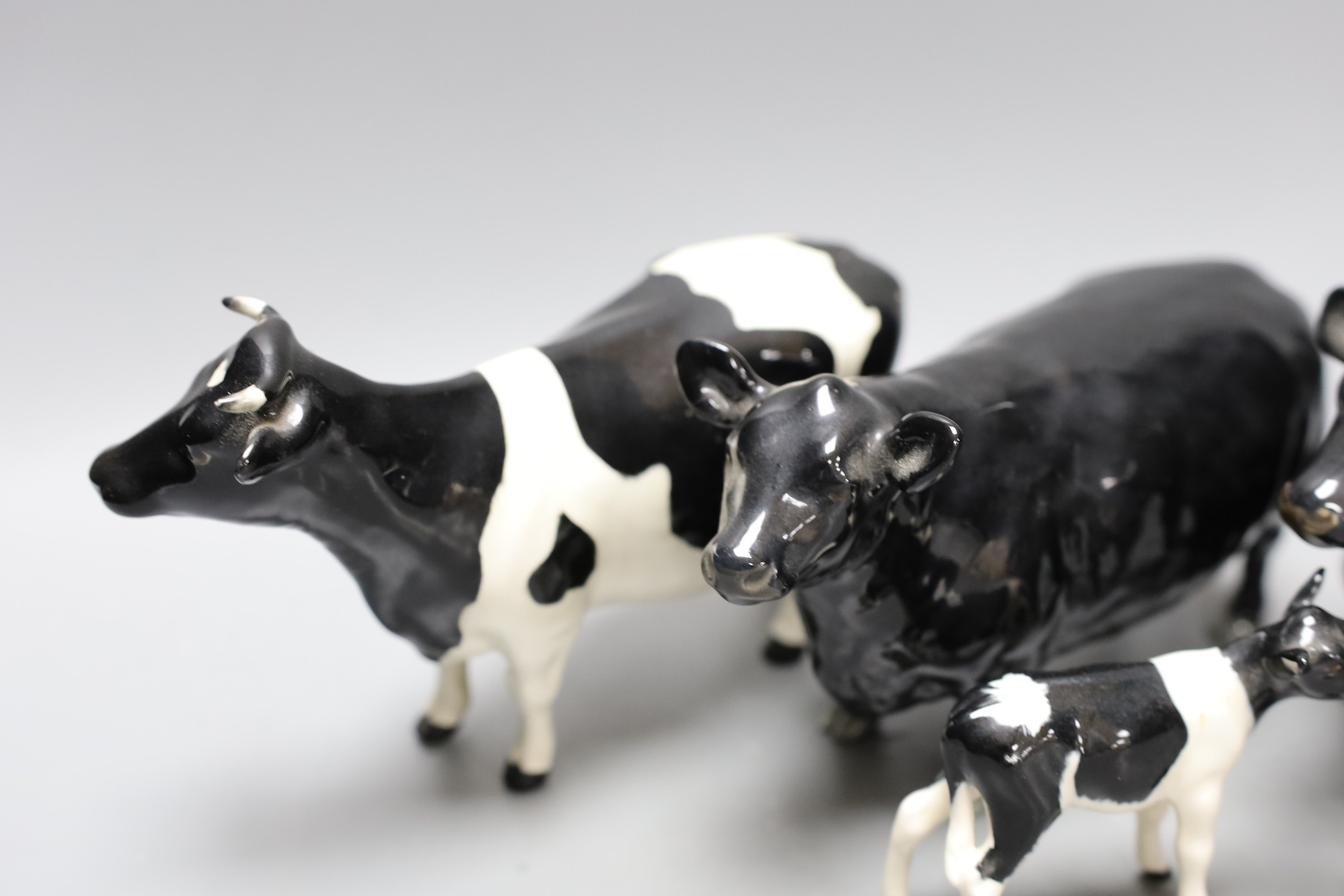 A Beswick Aberdeen Angus bull, cow and calf, together with a Godington Hilt Bar bull, cow and calf